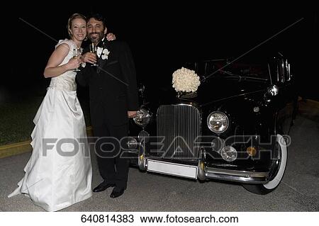 Portrait of a newlywed couple standing and drinking champagne View Large Photo Image Stock Image - Portrait of a newlywed couple standing and drinking champagne. Fotosearch