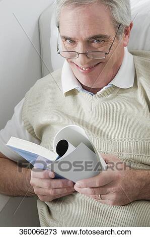 Portrait of a senior man holding a book and smiling View Large Photo Image Stock Image - Portrait of a senior man holding a book and smiling. Fotosearch