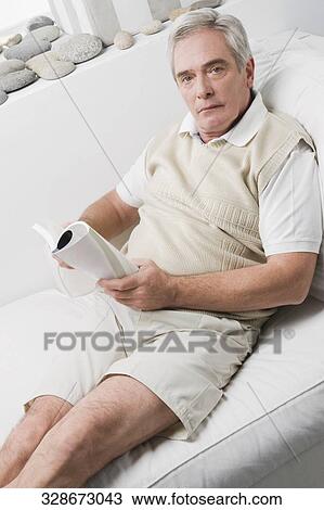 Portrait of a senior man reclining on a chaise lounge and holding a book View Large Photo Image Stock Image - Portrait of a senior man reclining on a chaise lounge and holding a book. Fotosearch