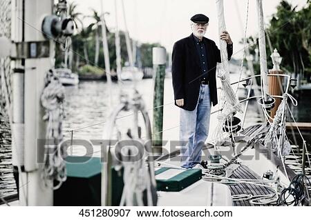 Stock Photo - Portrait of a senior man standing on a ship. Fotosearch