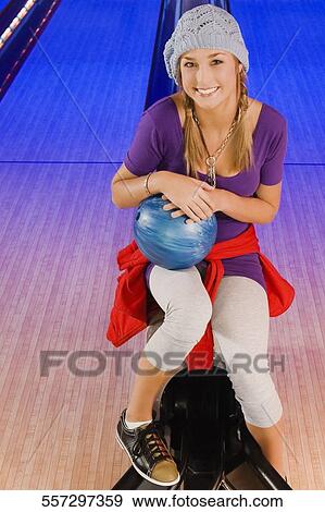 Portrait of a teenage girl holding a bowling ball and smiling View Large Photo Image Stock Photo - Portrait of a teenage girl holding a bowling ball and smiling. Fotosearch