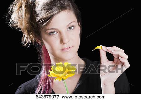 Portrait of a teenage girl holding a flower View Large Photo Image Stock Photo - Portrait of a teenage girl holding a flower. Fotosearch