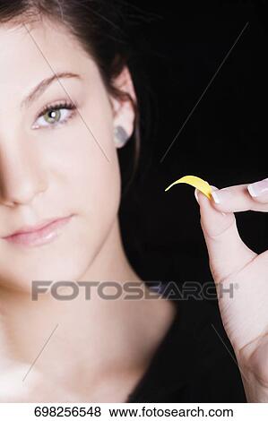 Stock Photo - Portrait of a teenage girl holding a petal. Fotosearch