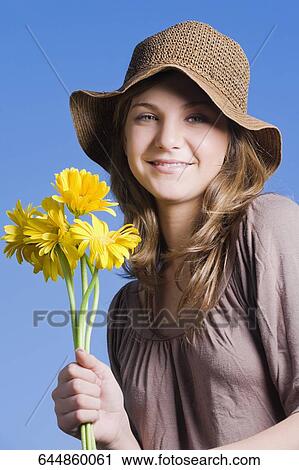 Portrait of a teenage girl holding bunch of flowers View Large Photo Image Stock Image - Portrait of a teenage girl holding bunch of flowers. Fotosearch