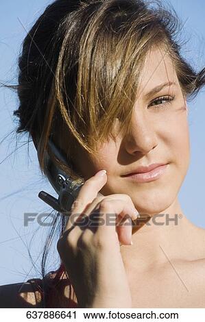 Stock Image - Portrait of a teenage girl talking on a mobile phone. Fotosearch