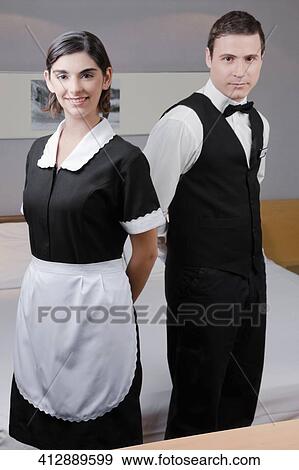 Portrait of a waiter and a waitress standing in a hotel room View Large Photo Image Stock Photo - Portrait of a waiter and a waitress standing in a hotel room. Fotosearch