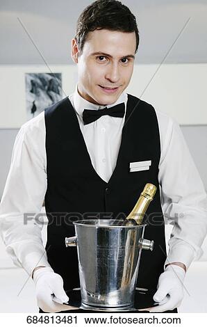 Portrait of a waiter holding a champagne bottle in an ice bucket View Large Photo Image Stock Image - Portrait of a waiter holding a champagne bottle in an ice bucket. Fotosearch