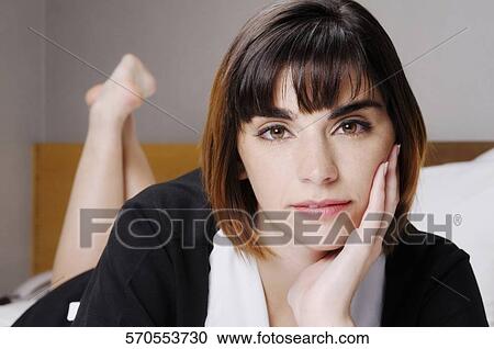 Portrait of a waitress lying on the bed View Large Photo Image Stock Image - Portrait of a waitress lying on the bed. Fotosearch