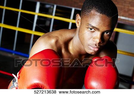 Stock Photo - Portrait of a young male boxer in a fighting stance. Fotosearch