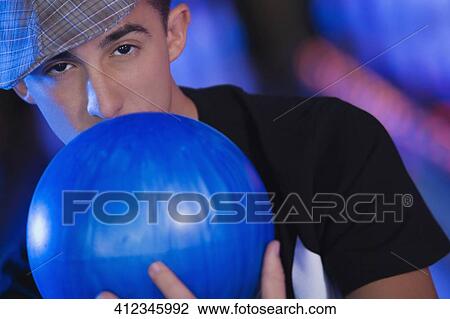 Portrait of a young man holding a bowling ball View Large Photo Image Stock Image - Portrait of a young man holding a bowling ball. Fotosearch