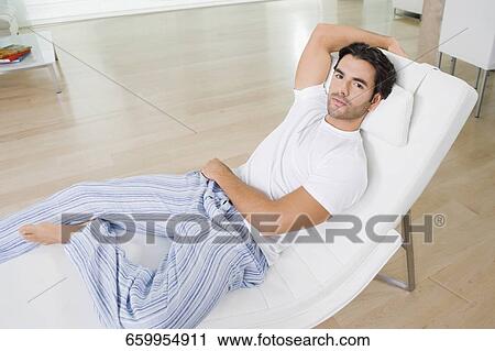Portrait of a young man resting on a reclining chair View Large Photo Image Stock Image - Portrait of a young man resting on a reclining chair. Fotosearch