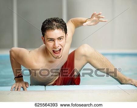 Portrait of a young man stepping out of a swimming pool View Large Photo Image Stock Image - Portrait of a young man stepping out of a swimming pool. Fotosearch