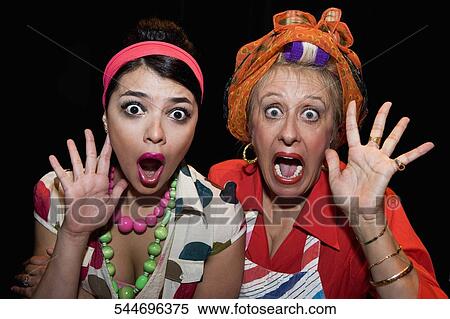 Stock Photography - Portrait of a young woman and her mother looking shocked. Fotosearch
