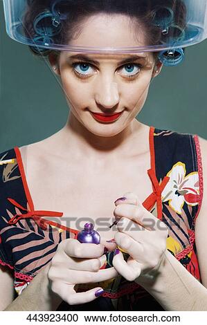 Portrait of a young woman applying nail polish View Large Photo Image Stock Image - Portrait of a young woman applying nail polish. Fotosearch