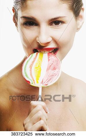 Portrait of a young woman eating a lollipop View Large Photo Image Stock Photography - Portrait of a young woman eating a lollipop. Fotosearch