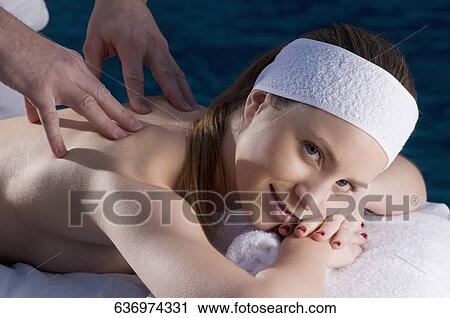 Portrait of a young woman getting back massage from a massage therapist View Large Photo Image Stock Image - Portrait of a young woman getting back massage from a massage therapist. Fotosearch