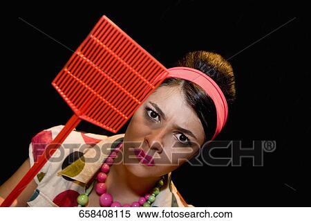 Portrait of a young woman holding a fly swatter View Large Photo Image Stock Photography - Portrait of a young woman holding a fly swatter. Fotosearch