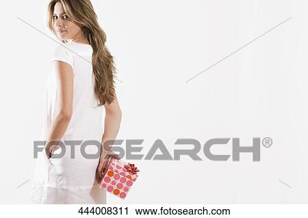 Portrait of a young woman holding a gift View Large Photo Image Stock Image - Portrait of a young woman holding a gift. Fotosearch