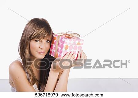 Portrait of a young woman holding a gift View Large Photo Image Stock Photo - Portrait of a young woman holding a gift. Fotosearch