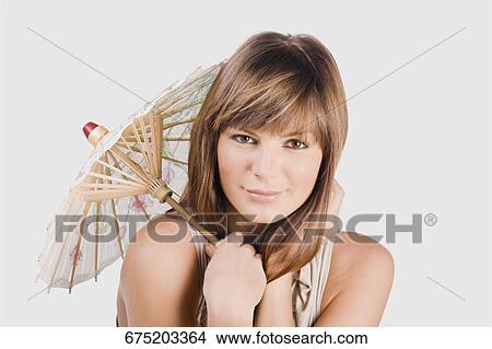 Portrait of a young woman holding a parasol View Large Photo Image Picture - Portrait of a young woman holding a parasol. Fotosearch