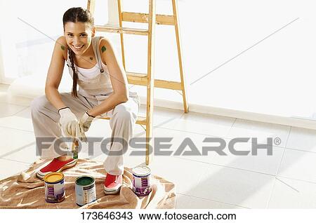 Portrait of a young woman holding a paintbrush View Large Photo Image Stock Image - Portrait of a young woman holding a paintbrush. Fotosearch