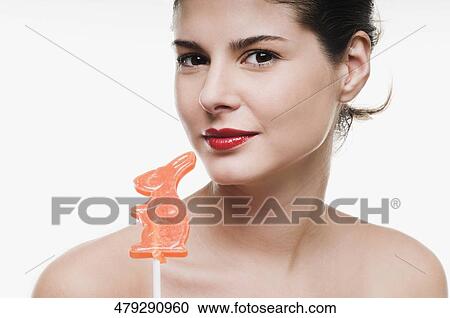 Portrait of a young woman holding a lollipop View Large Photo Image Stock Image - Portrait of a young woman holding a lollipop. Fotosearch