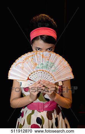 Portrait of a young woman holding a folding fan View Large Photo Image Stock Image - Portrait of a young woman holding a folding fan. Fotosearch