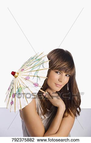 Portrait of a young woman holding a parasol View Large Photo Image Stock Image - Portrait of a young woman holding a parasol. Fotosearch