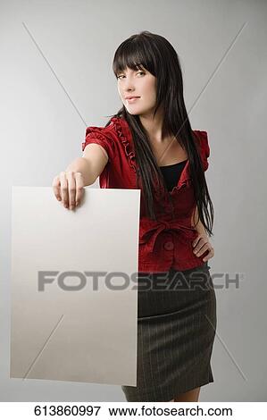 Stock Photo - Portrait of a young woman holding a sheet of paper and smiling. Fotosearch