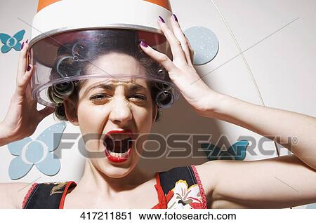Portrait of a young woman holding hair dryer over her head and shouting View Large Photo Image Stock Image - Portrait of a young woman holding hair dryer over her head and shouting. Fotosearch