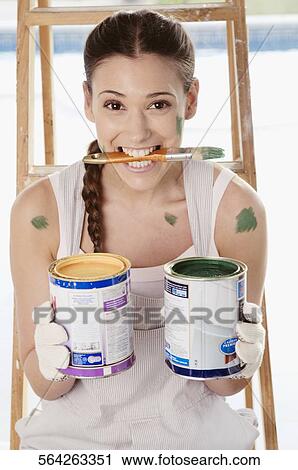 Portrait of a young woman holding paint cans View Large Photo Image Stock Image - Portrait of a young woman holding paint cans. Fotosearch