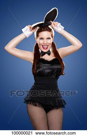 Stock Image - Portrait of a young woman in rabbit costume. Fotosearch
