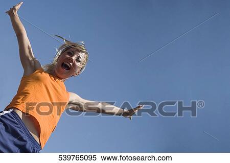 Portrait of a young woman jumping View Large Photo Image Stock Photography - Portrait of a young woman jumping. Fotosearch