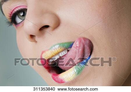 Stock Image - Portrait of a young woman licking her lips. Fotosearch