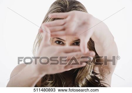 Portrait of a young woman looking through her hands View Large Photo Image Stock Image - Portrait of a young woman looking through her hands. Fotosearch