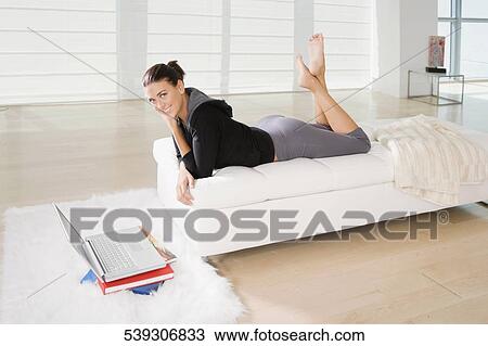 Portrait of a young woman lying on the bed and smiling View Large Photo Image Stock Image - Portrait of a young woman lying on the bed and smiling. Fotosearch
