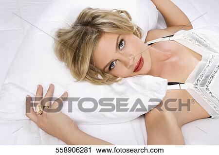 Portrait of a young woman lying on the bed View Large Photo Image Stock Image - Portrait of a young woman lying on the bed. Fotosearch