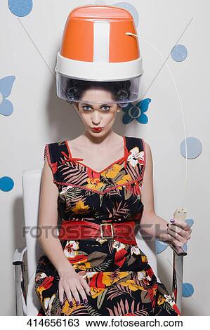 Portrait of a young woman sitting under hair dryer View Large Photo Image Stock Image - Portrait of a young woman sitting under hair dryer. Fotosearch
