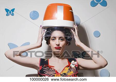 Portrait of a young woman sitting under hair dryer View Large Photo Image Stock Photograph - Portrait of a young woman sitting under hair dryer. Fotosearch