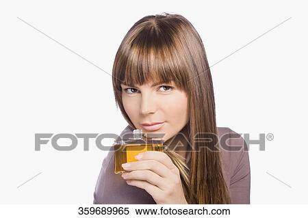 Portrait of a young woman smelling perfume View Large Photo Image Stock Photography - Portrait of a young woman smelling perfume. Fotosearch