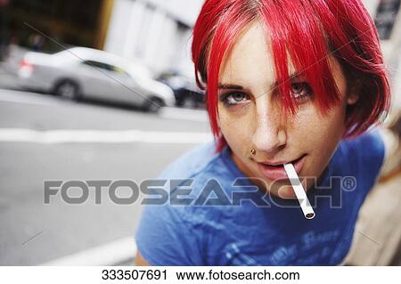 Stock Image - Portrait of a young woman smoking a cigarette. Fotosearch