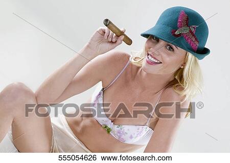 Stock Photograph - Portrait of a young woman smoking a cigar. Fotosearch