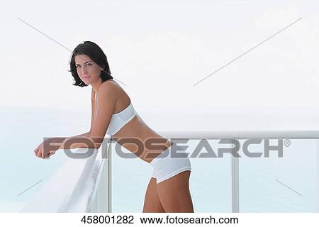 Portrait of a young woman standing in a balcony View Large Photo Image Stock Image - Portrait of a young woman standing in a balcony. Fotosearch
