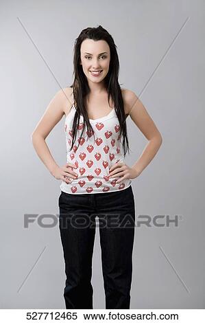 Portrait of a young woman standing with arms akimbo View Large Photo Image Stock Photography - Portrait of a young woman standing with arms akimbo. Fotosearch