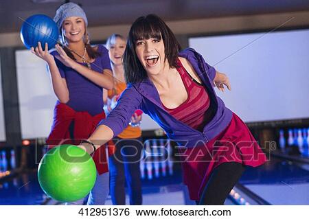 Portrait of a young woman throwing a ball with her friends in the background View Large Photo Image Stock Photograph - Portrait of a young woman throwing a ball with her friends in the background. Fotosearch