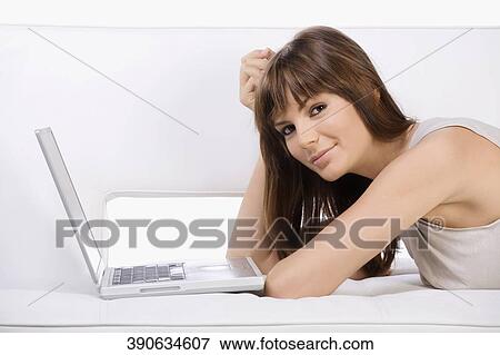 Portrait of a young woman using a laptop View Large Photo Image Stock Photo - Portrait of a young woman using a laptop. Fotosearch