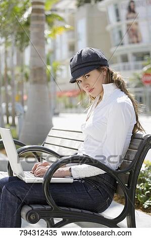 Portrait of a young woman using a laptop View Large Photo Image Stock Photography - Portrait of a young woman using a laptop. Fotosearch