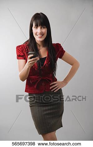 Portrait of a young woman using a mobile phone and smiling View Large Photo Image Stock Photo - Portrait of a young woman using a mobile phone and smiling. Fotosearch