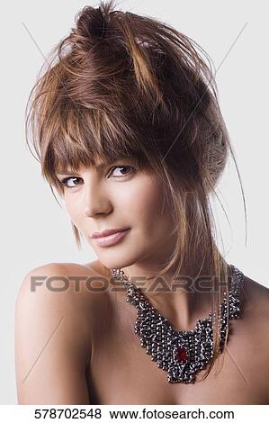 Portrait of a young woman wearing a necklace View Large Photo Image Stock Photo - Portrait of a young woman wearing a necklace. Fotosearch