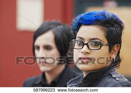 Portrait of a young woman with a young man behind her View Large Photo Image Stock Image - Portrait of a young woman with a young man behind her. Fotosearch